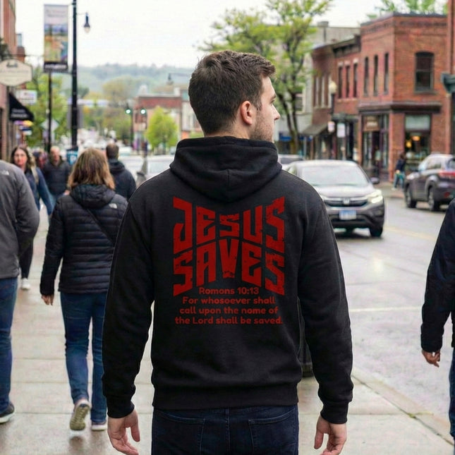 Person wearing a black hoodie with 'Jesus Saves' text on the back in an urban setting.