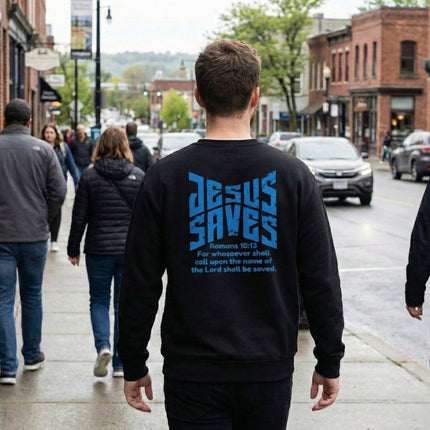 Person wearing a black sweatshirt with 'Jesus Saves' text on the back, walking down a city street.