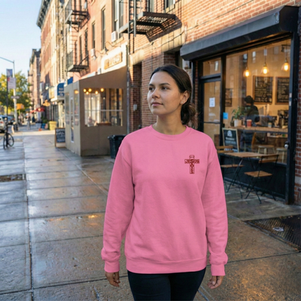 Woman wearing a pink sweatshirt with a logo on a city street.
